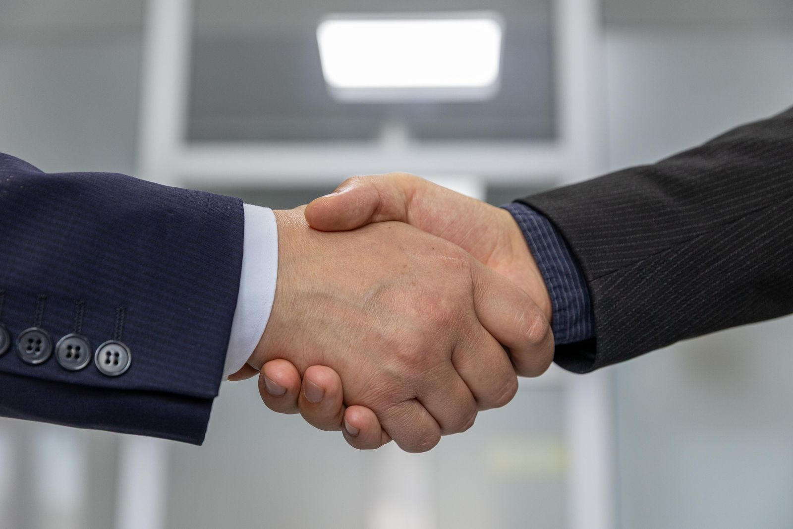 Industrial partnership handshake at a precision manufacturing facility